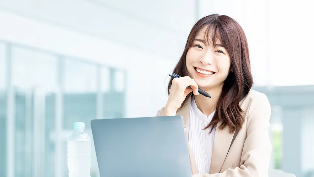 パソコンを使う笑顔のビジネスウーマン