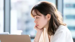 PCを前に悩むビジネス女性