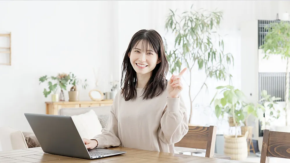 パソコンを使いながら指差しをする女性