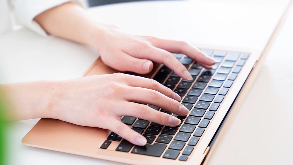 パソコンでタイピングする女性の手