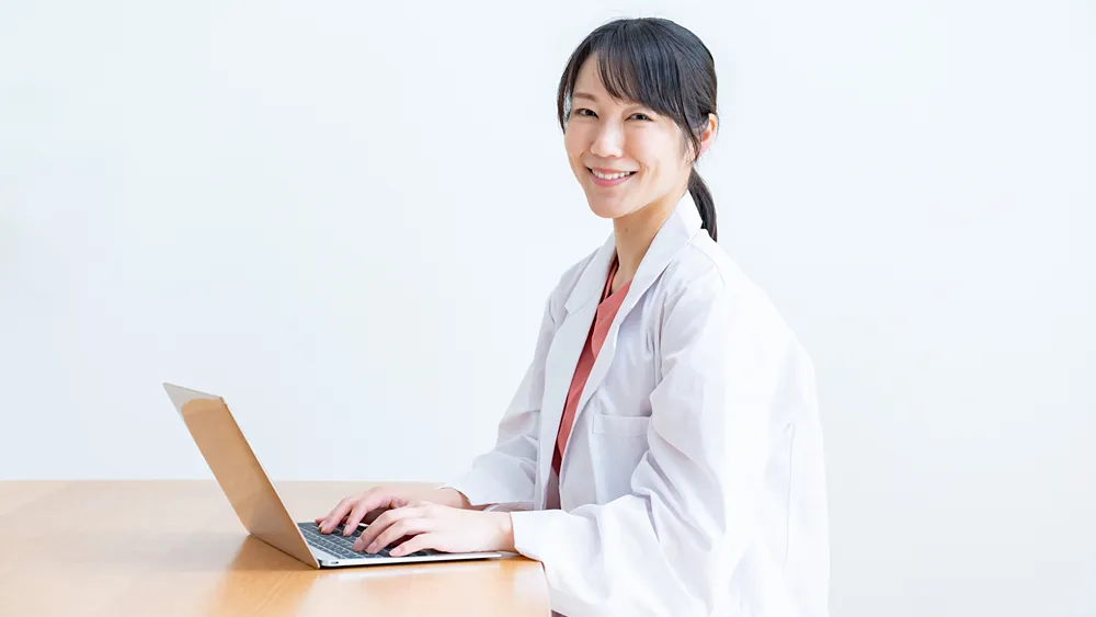 パソコン作業をする白衣を着た女性